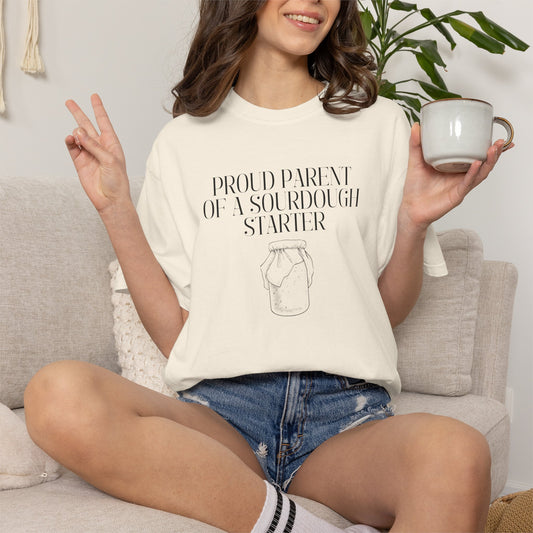Model wearing an ivory Comfort Colors® "Proud Parent of a Sourdough Starter" t-shirt with vintage sourdough jar graphic. Funny sourdough shirt for bakers, bread makers, and homemade bread enthusiasts.