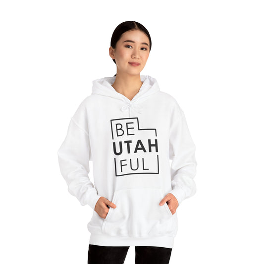 Woman wearing a white Be-Utah-Ful hoodie with the black Utah-outline design, Utah pride hoodie for travelers.