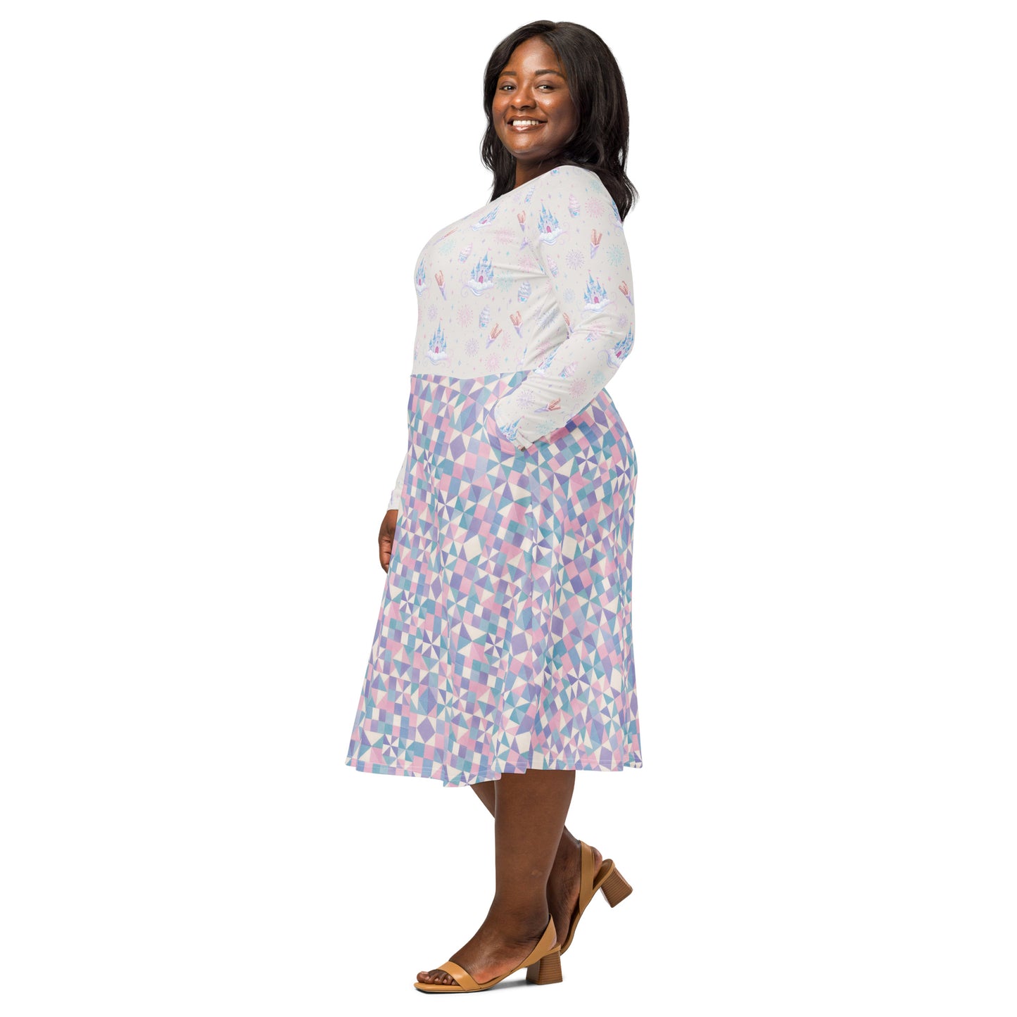 A woman modeling a long-sleeve midi dress with castles, churros, fireworks and ice cream scattered across the top and  a geometric skirt pattern in pastel pink, blue, and purple that also has pockets