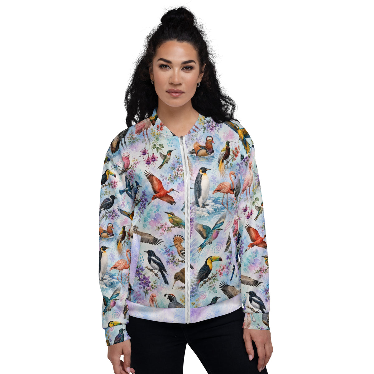 A woman modeling a zip-up bomber jacket with a vibrant, all-over print of various colorful birds on a light pastel watercolor background, set against a plain white studio backdrop.