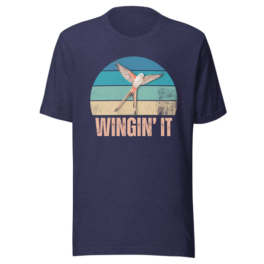 A heather navy blue Wingin' It graphic t-shirt with a Wingspan-inspired scissor-tailed flycatcher over a colorful retro sunset design