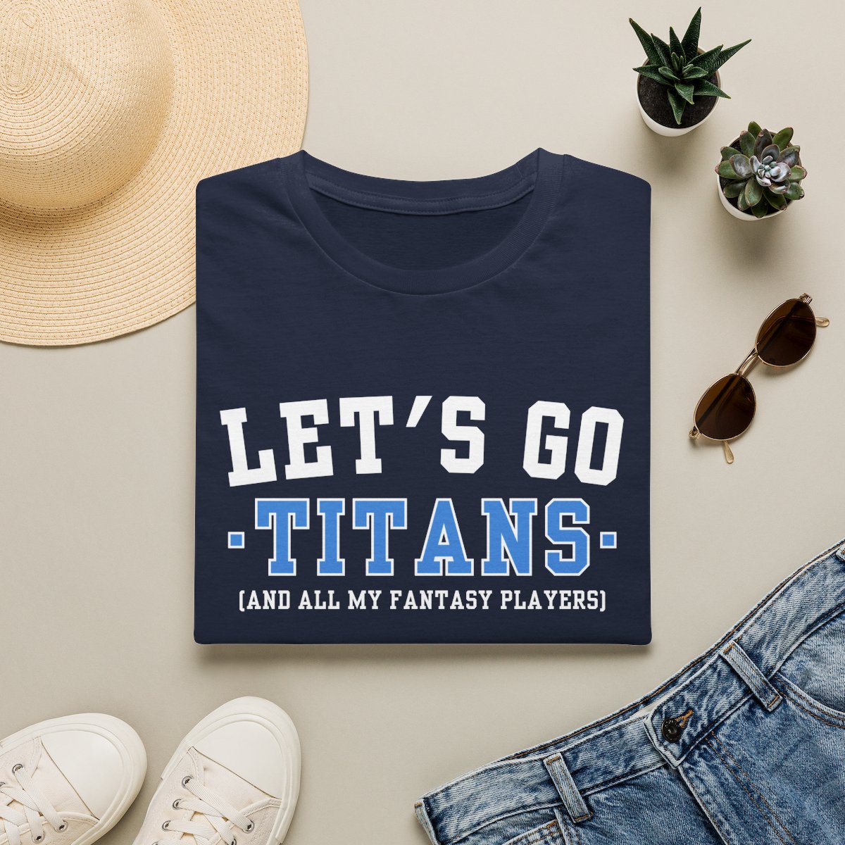 Navy Titans fantasy football tee folded on a neutral flat lay with a straw hat and sneakers
